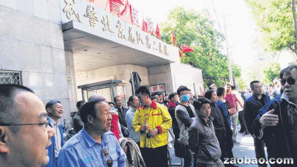 北京武警二院生物免疫疗法患者家属昨天再次聚集医院门口维权，引发警方高度重视，十多辆警车停靠医院附近严阵以待。（读者提供）