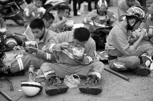 消防队员坐在地上吃早饭 现代快报/ZARKE南京记者 徐洋 摄