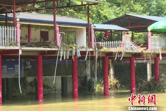 河边一处房屋上挂满水草 董晓斌 摄