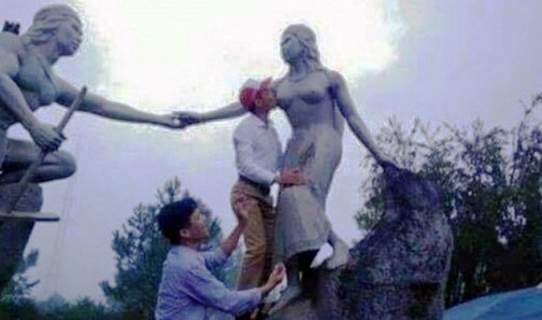 照片显示，一位越南官员正在亲吻女性雕像的赤裸胸部（网页截图）