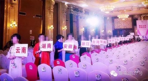 “创造丰盛”北京盛典现场，来自全国多个省市的“督导”拿着各省的牌子引导学员就座。(官方微信公号显示)