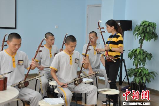 图为福建省艺术馆的老师正在教导服刑人员演奏二胡。 林小和 摄 图为福建省艺术馆的老师正在教导服刑人员演奏二胡。 林小和 摄