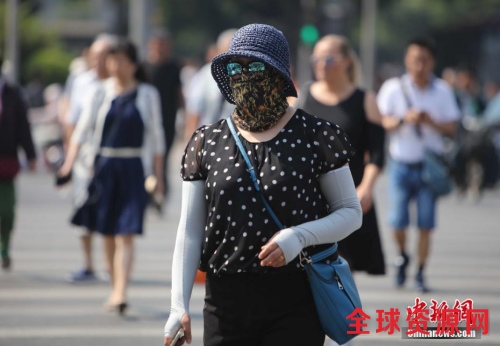 资料图：5月17日，北京街头的民众防晒出行。当日北京市气象台发布今年首个高温黄色预警。中新社记者 杨可佳 摄