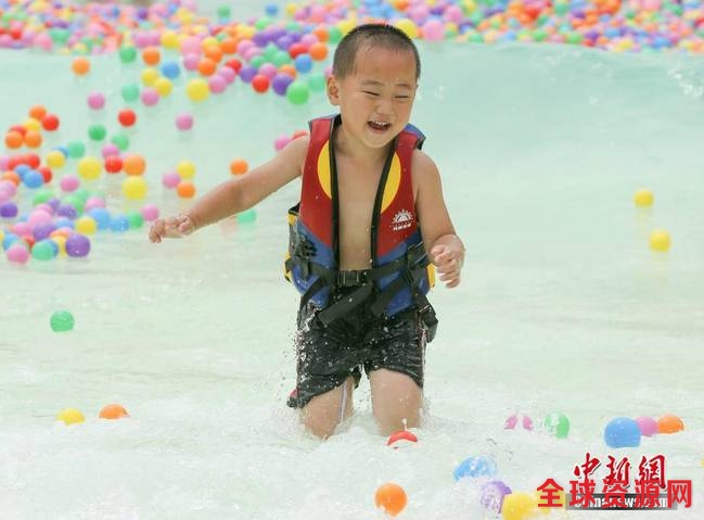 6月4日，孩童在飘着彩色海洋球的玛雅水公园里内戏水。