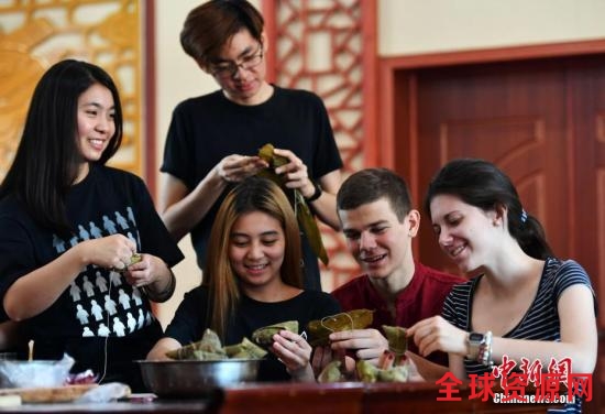 资料图：5月24日，端午节临近，留学生们尝试包粽子。中新社记者 翟羽佳 摄