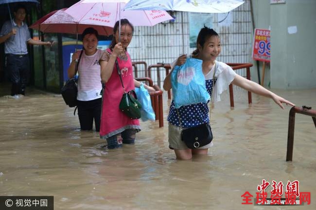 图为南京市雨花台区，市民在水中艰难出行。
