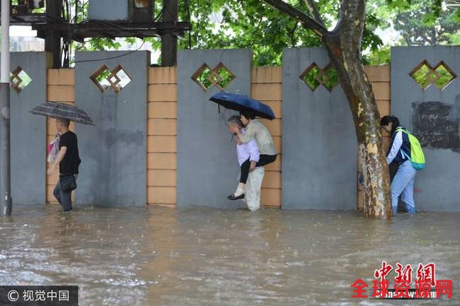 6月10日，南京市雨花台区，市民在水中艰难出行。