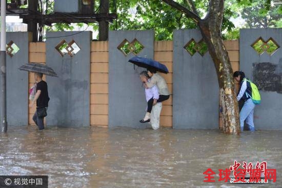 6月10日，南京市雨花台区，市民在水中艰难出行。图片来源：视觉中国