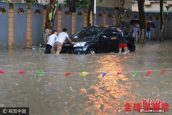 图为6月10日，南京市雨花台区，几个男子推着抛锚的汽车。文字来源：中国天气网图片来源：视觉中国