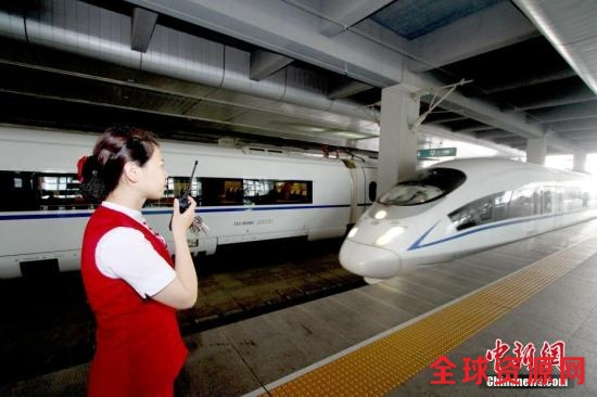 资料图：6月1日，天津站，高铁工作人员迎接入站的京津城际列车。中新社记者 张道正 摄