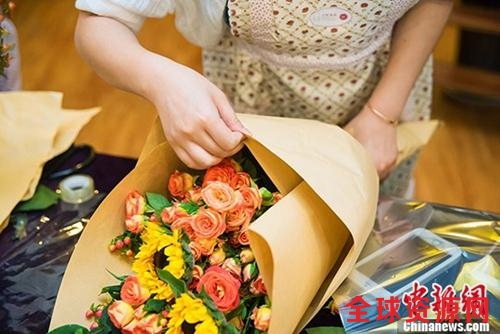 资料图：2016年6月19日是父亲节，武汉十余市民亲手插花献父亲表爱意。一位市民正在整理即将完成的花束。 周博 摄
