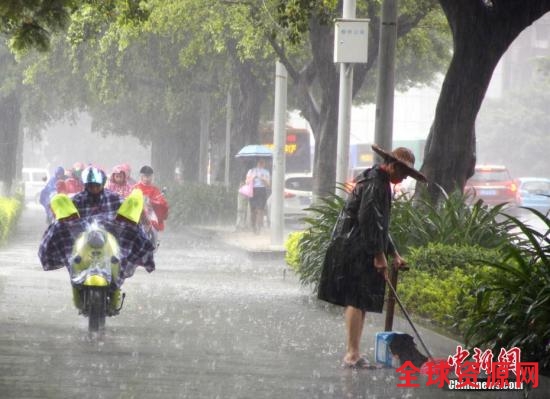 资料图：6月16日，广西柳州市遭暴雨侵袭，一名清洁工在雨中扫地。 中新社记者 朱柳融 摄