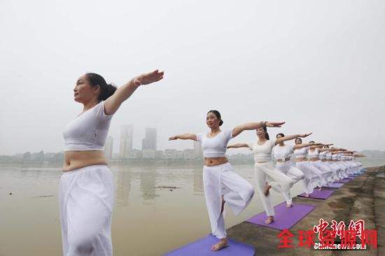 6月21日“国际瑜伽日”，瑜伽爱好者在珠江上游的融江广西柳州市融安县城段江边晨练瑜伽。谭凯兴 摄