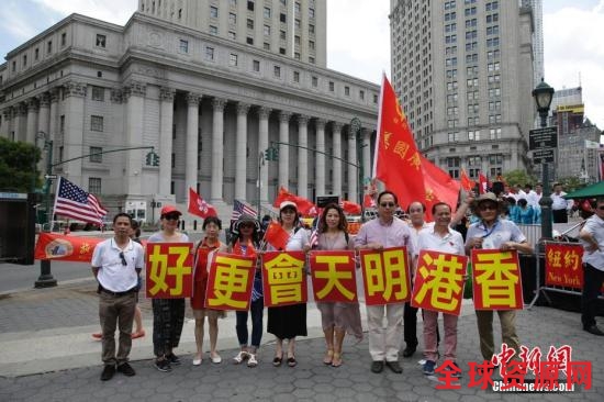 当地时间6月25日，美东各界华侨华人庆祝香港回归二十周年大会在纽约曼哈顿弗利广场举行。图为参会华人华侨打出“香港明天会更好”标语。中新社记者 廖攀 摄