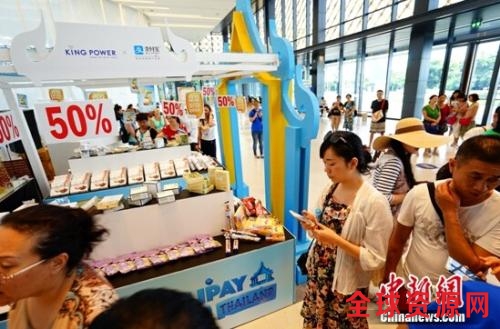 资料图:某消费者在线下商品展台前选购。 资料图:某消费者在线下商品展台前选购。