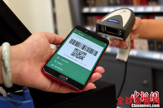 6月底,成都某便利店内,年轻人正在使用手机二维码支付。中新社记者 张浪 摄 6月底,成都某便利店内,年轻人正在使用手机二维码支付。中新社记者 张浪 摄