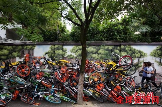 9月19日，南京碑亭巷内，各种颜色的共享单车堆放在一起，色彩交织的“叠罗汉”景象令过往的市民侧目。 中新社记者 泱波 摄