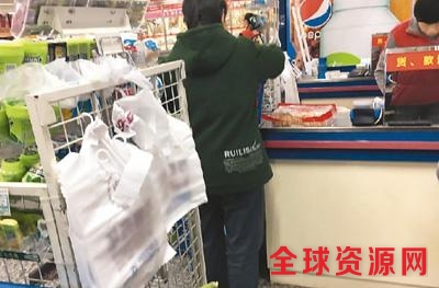 北京市朝阳区金台路一家超市内收银处悬挂的塑料购物袋。 本报记者 彭训文摄