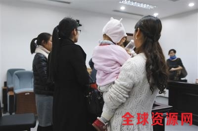 昨日，一名当事女员工抱着孩子在法庭上接受记者采访。新京报记者 王贵彬 摄