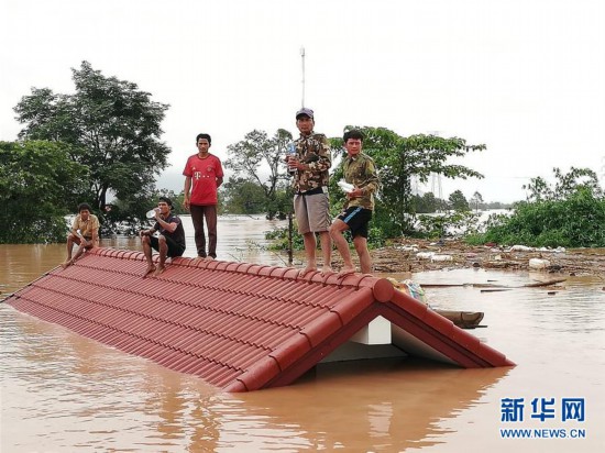 7月24日，在老挝阿速坡，居民在屋顶躲避溃坝事故带来的洪水。
