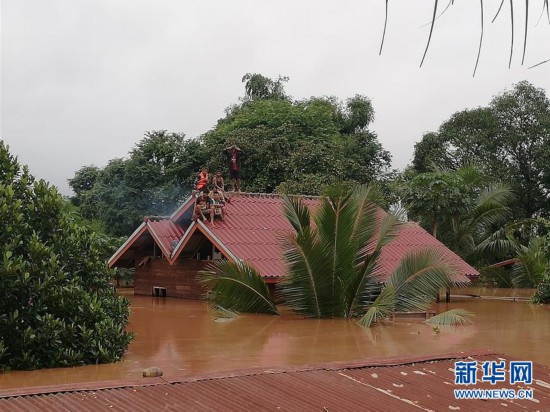 7月24日，在老挝阿速坡，居民在屋顶躲避溃坝事故带来的洪水。
