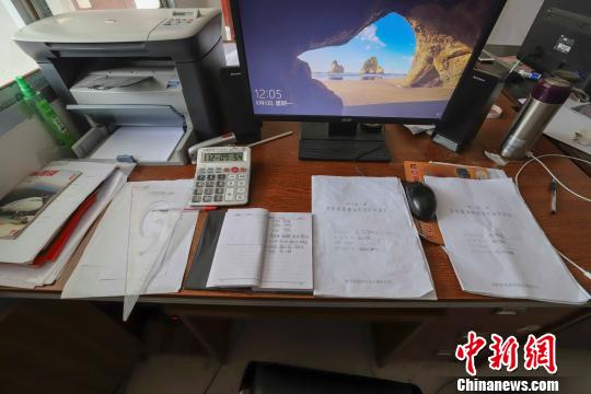 8月7日，湖南龙山县茅坪乡国土所国土员彭鹏的办公桌子上摆放着没写完的笔记本。 张军 摄