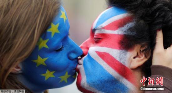 图为2016年6月23日，英国两个民众涂着欧盟旗帜和英国旗帜的脸谱深情一吻，满满的不舍。