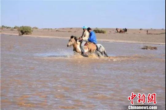 图为当地牧民骑马过河。 额济纳旗委宣传部供图摄