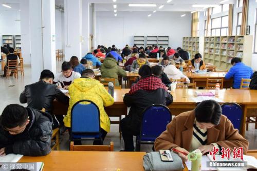资料图：2017年11月22日，山东青岛，考研生在图书馆内埋身书海认真复习。小老茂 摄 图片来源：视觉中国