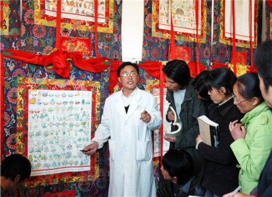 藏医医生向学生介绍在古籍中记载的用于药浴的草药。教科文组织提供