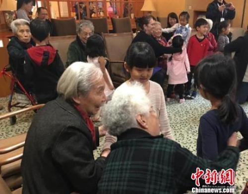 资料图：北京一家养老机构内，老人们与幼儿园小朋友一起做游戏。 杜燕 摄 
