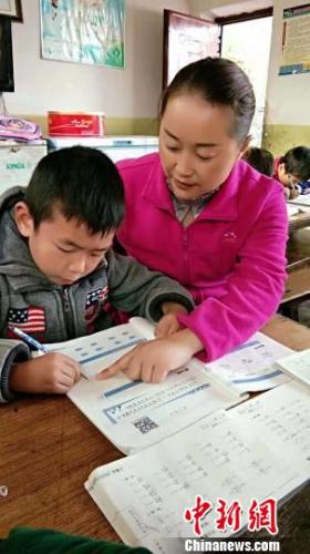 张蓉辅导学生学习。 钟欣 摄 点击进入下一页