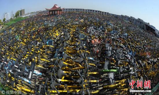 为了不影响市民正常出行，城管部门将不文明停放的单车集中停放，代为保管。图片来源：视觉中国
