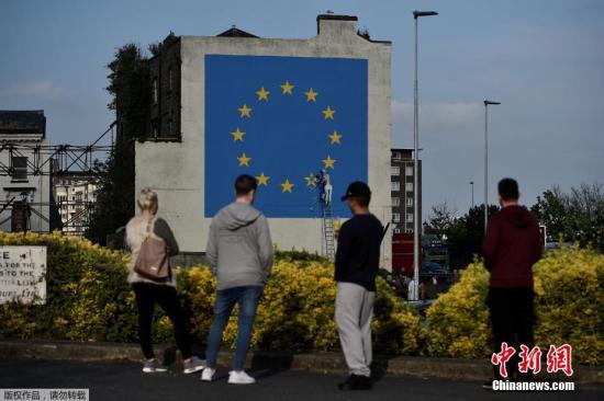 资料图：当地时间2017年5月7日，英国多佛，一名街头艺术家班克西创作了一幅画，画面中一名工人正从欧盟12星旗帜上抹掉一颗星，寓意着英国将脱离欧盟。
