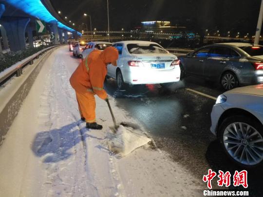 环卫工人在街头扫雪除冰。南京城管
