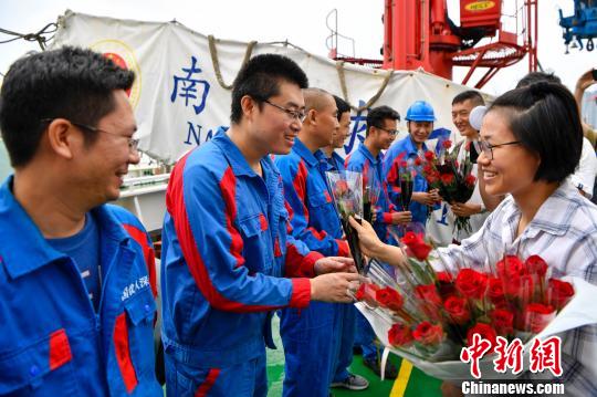 3月10日上午，“探索一号”科考船搭载“深海勇士”号载人潜水器靠港三亚。图为接船人员为科考队员献花。 骆云飞 摄