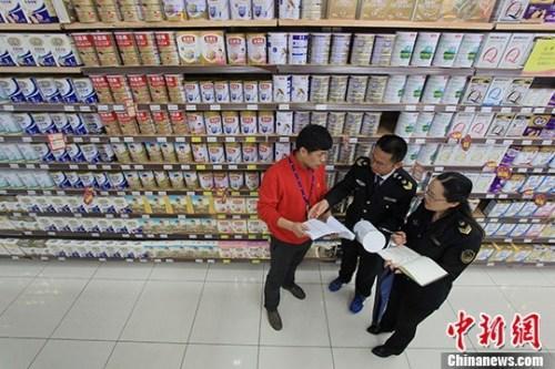 资料图：超市内工作人员在检查奶粉。中新社记者 张娅子 摄