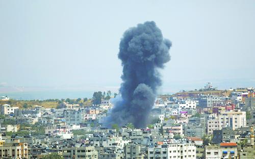 截至5日，已有至少8名巴勒斯坦人和3名以色列人在军事冲突中丧生。图为以军轰炸造成的浓烟在加沙城升起。
