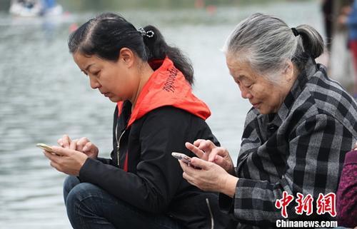 图为中国中老年女性使用智能手机上网。(资料图) 刘占昆 摄