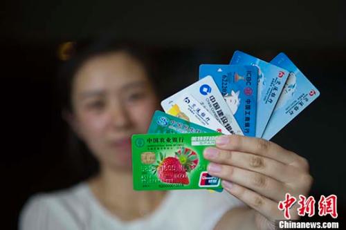 资料图:民众展示银行卡。 <a target='_blank' href='http://www.chinanews.com/'>中新社记者 张云 摄 点击进入下一页