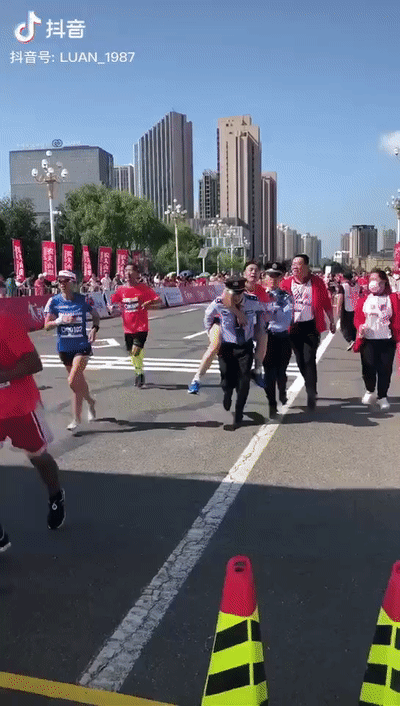 马拉松选手最后100米出现意外 警察背他冲向终点