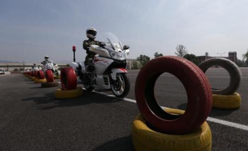国宾护卫队员驾驶摩托车通过宽1.1米、长100米的轮胎通道。王双战/摄