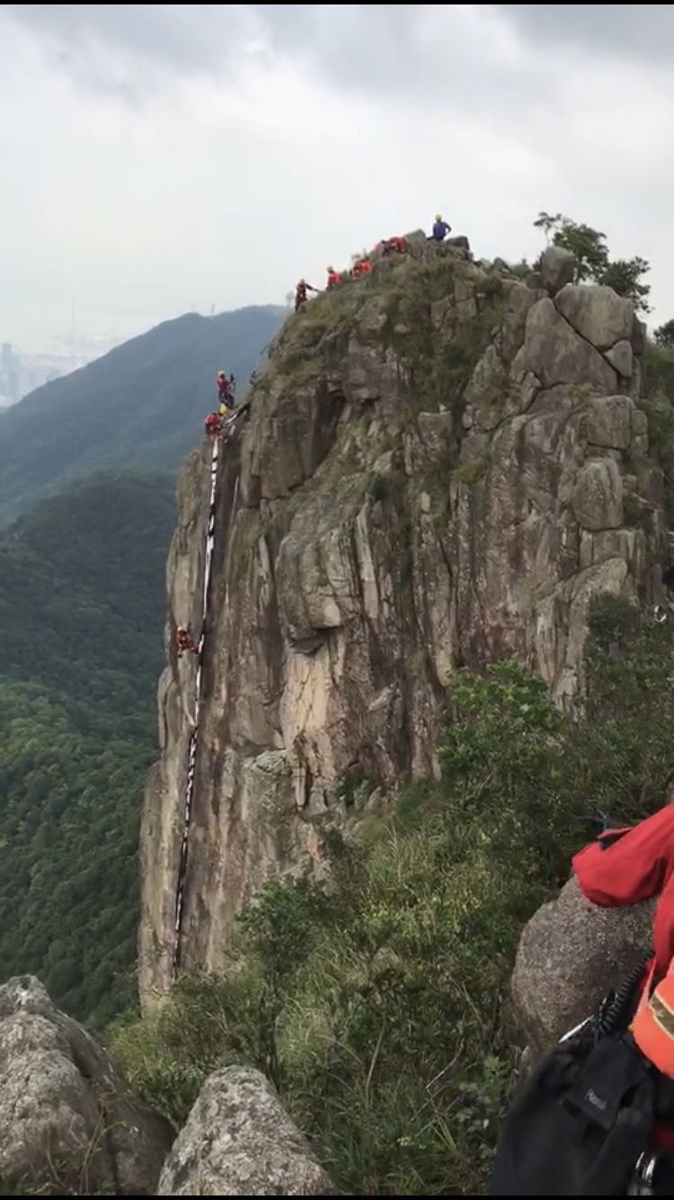 爱国爱港团体登狮子山挥国旗 涉险摘除反对派标语