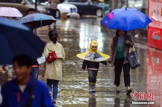 资料图:市民雨中出行。 <a target='_blank' href='http://www.chinanews.com/'>中新社记者 刘新 摄 点击进入下一页