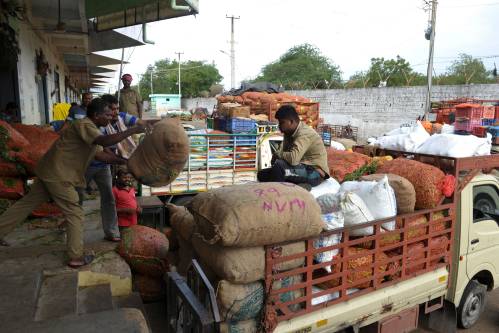 图为在印度海得拉巴，工人们将成包的蔬菜装车。新华社/法新