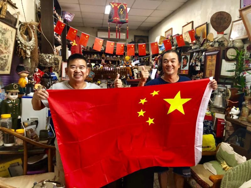 金门居民王明宗（右）和朋友一起展示五星红旗。来源：香港大公网