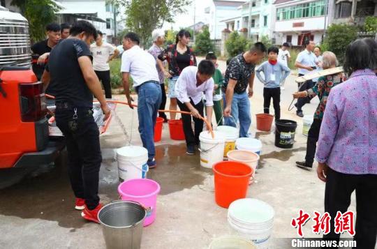 在江西鹰潭市余江区黄庄乡黄庄村，村民们用水桶接水回家。 刘占昆 摄
