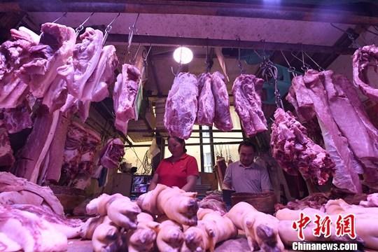 资料图:农贸市场内,商贩正在摆放猪肉。中新社记者 陈超 摄 资料图:农贸市场内,商贩正在摆放猪肉。中新社记者 陈超 摄