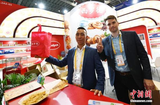 资料图：第二届中国国际进口博览会上，白俄罗斯参展商推介具有百年历史的饼干品牌。中新社记者 毛建军 摄
