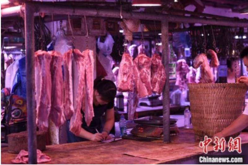 资料图为重庆一农贸市场内的商家挂满充足的猪肉。<a target=